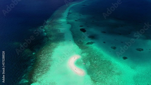 Aerial Tilt Up Shot Of Tourists At Beach Island Amidst Turquoise Sea, Drone Flying Backward On Sunny Day - Thulusdhoo, Maldives photo