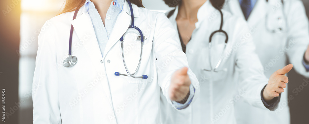 Group of doctors are standing as a team while offering their helping hands for shaking hand or saving people's life. Medicine concept during Coronavirus pandemic. Covid-2019 Group of doctors are standing as a team while offering their helping hands for shaking hand or saving people's life. Medicine concept during Coronavirus pandemic. Covid-2019