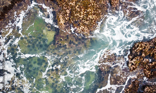 Aerial view of the sea rocks cliffs in the ocean. Beautiful sea wallpaper for tourism and advertising. Stormy landscape, drone photo