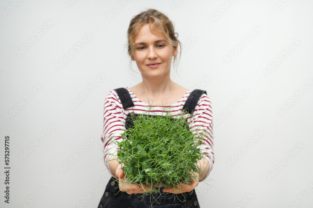 A woman is holding a micro green in her hands. Close-up.