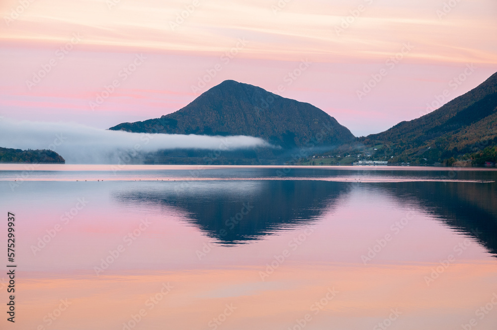 mountains reflected in the sea in pink light mountains reflected in the sea in pink light