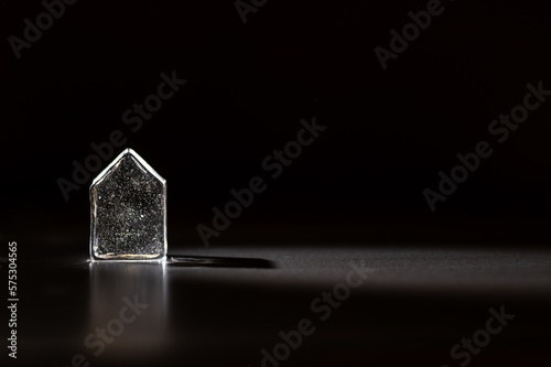 Fototapeta Naklejka Na Ścianę i Meble -  A figure of a glass or ice house on a black background. Crystal house