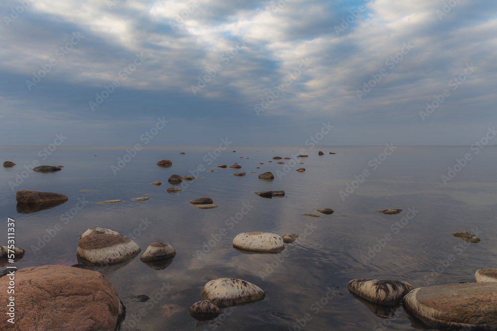 Baltic sea on a gloomy autumn day, view from a shore with stones.