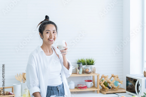 Young Woman drinking healthy fruit vegetable smoothie. Woman Looking camera. Healthy women drinking fruits smoothie.