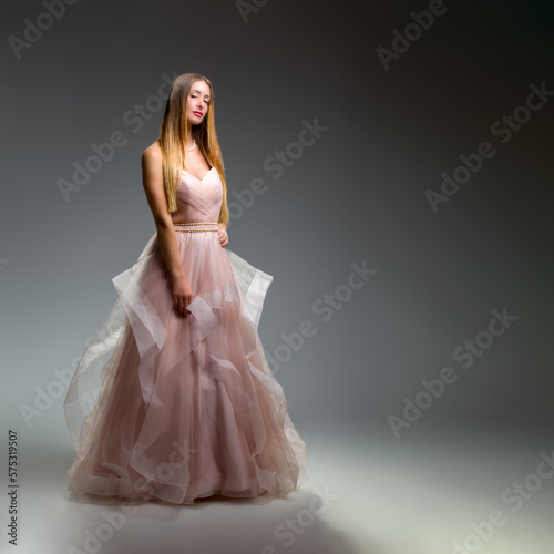 Elegant fashion. Stunning woman in elegant long dress in studio. Luxury evening fashion. Glamour fashion model. Elegance.