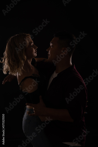 a man and a woman in love dance in a dark hall