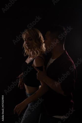 a man and a woman in love dance in a dark hall