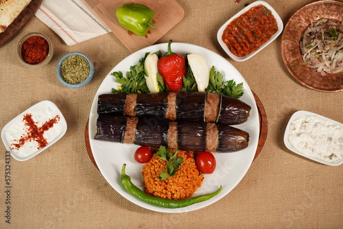 Traditional Turkish eggplant kebab or kebap meat food, appetizers, raki and salgam on table from top view in turkish restaurant. photo