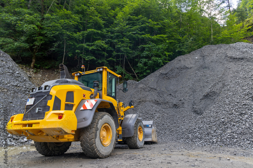 yellow digger with grey gravel for construction of the road yellow digger with grey gravel for construction of the road