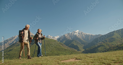 Fototapeta Mature caucasian couple on vacation, having a hike in spring mountains, spending