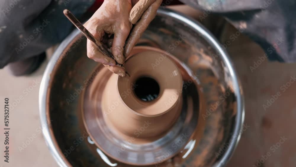 Female potter make clay pot on the pottery wheel. Close up shot of potter making ceramic pot on pottery wheel at workshop, slow motion. Creativity and traditional crafts concept