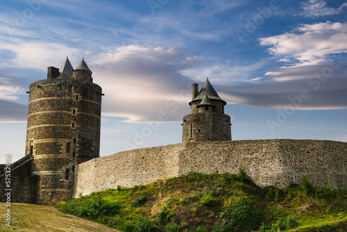 View of the wall and towers of the medieval castle of the French town of Fougeres built in the 13th century, with a background of blue sky and clouds at sunset. photo