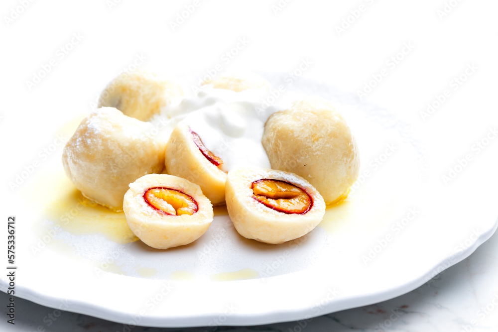 plum dumplings with sour cream, powder sugar and melted butter plum dumplings with sour cream, powder sugar and melted butter