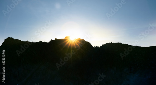 Sonnenaufgang im Gebirge vor einem Gebirgskamm