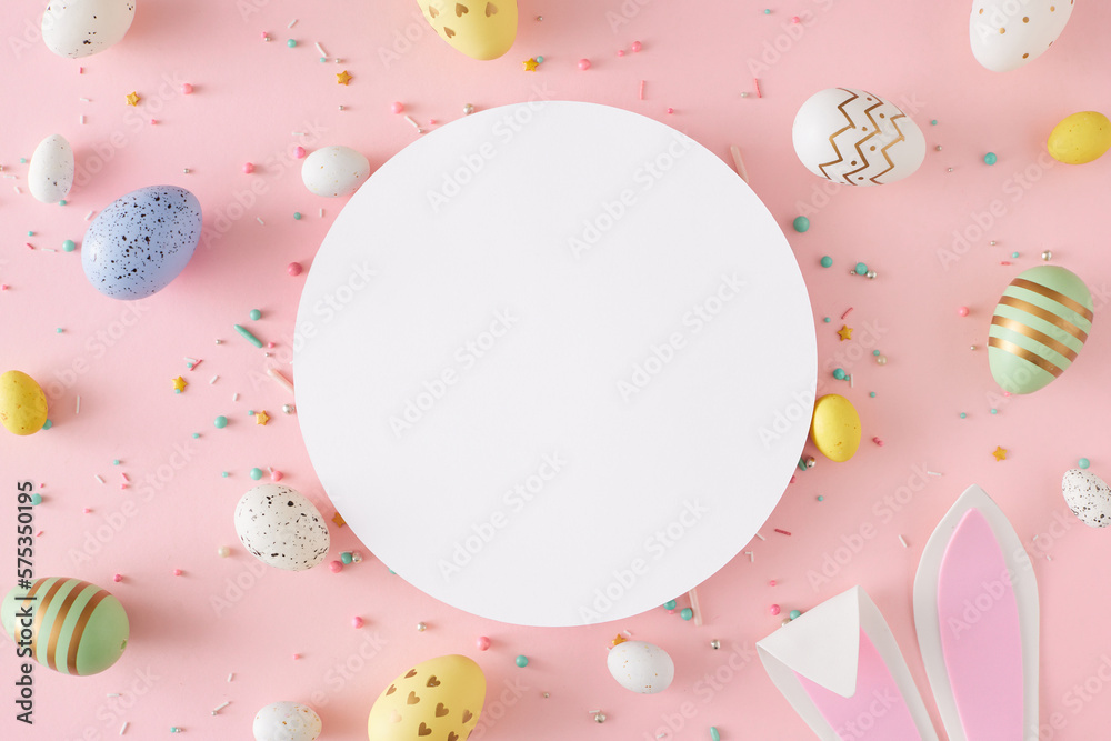 Easter decor concept. Flat lay photo of white circle easter bunny ears yellow blue white and green eggs sprinkles on pastel pink background with blank space - obrazy, fototapety, plakaty 