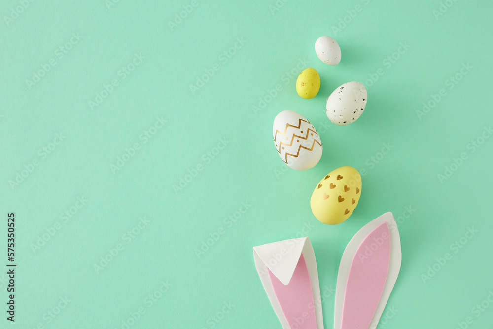 Easter concept. Top view photo of easter bunny ears yellow white eggs on isolated teal background with copy space. Holiday card idea - obrazy, fototapety, plakaty 