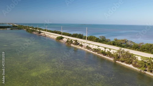 Car traveling along Florida Keys US1 road with ocean on both sides and power lines. photo