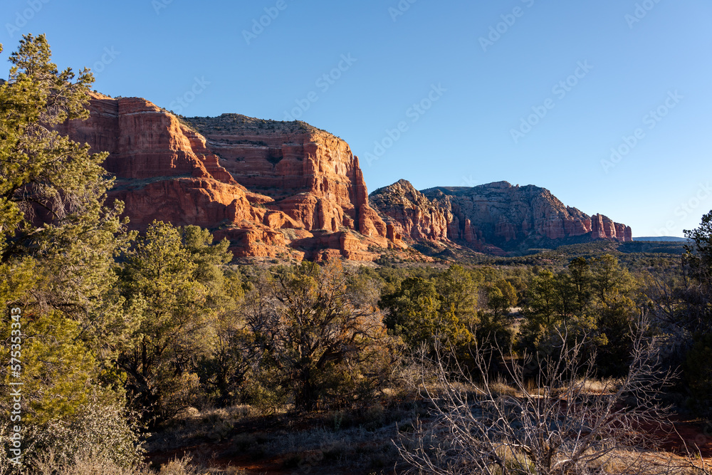 Vibrant red rocks of Courthouse Butte in the morning sun, Sedona, Arizona, USA. Scenic landscape with the famous geological formations under a sunny blue sky. Popular hiking trail in teh United States