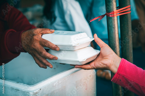 Poor people's hands share free food from volunteers who donate food : concept of feeding, sharing food