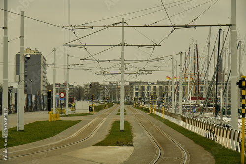 Fototapeta Naklejka Na Ścianę i Meble -  Ligne du Tram de la Côte avec ses caténaires reliant toutes les cités balnéaires belges sous un ciel sombre à Ostende 