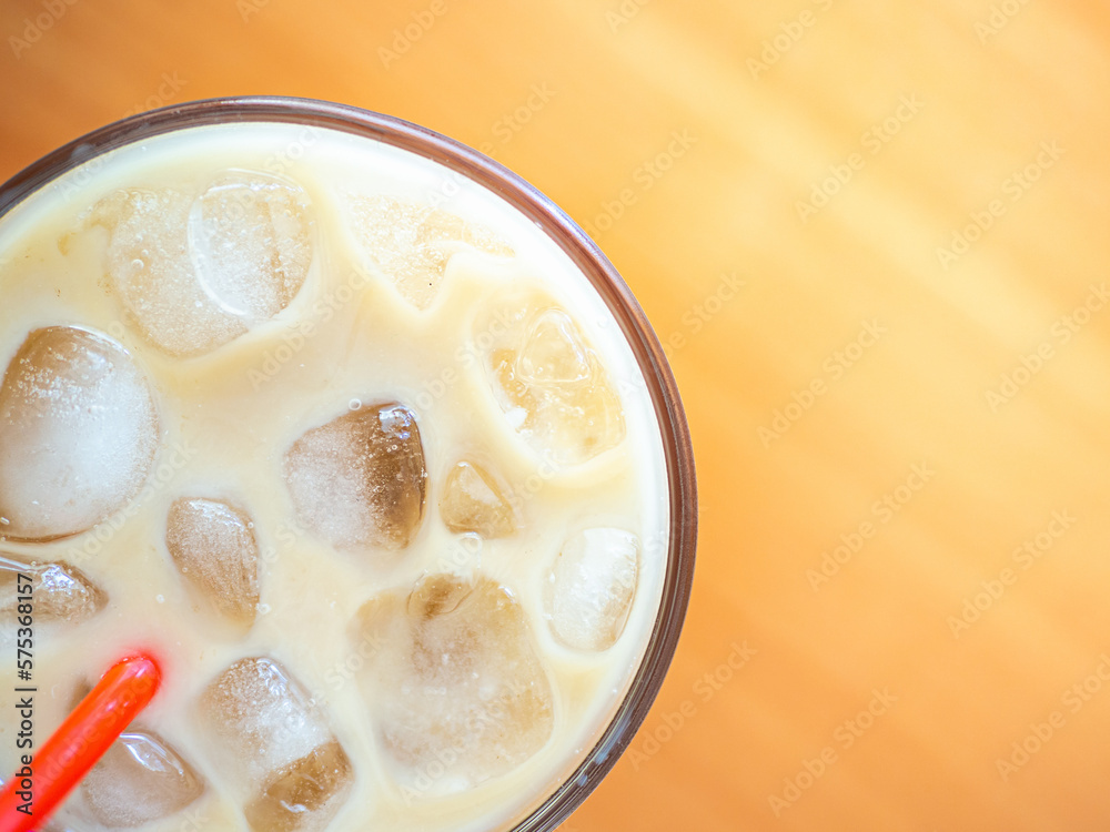 Ice coffee on a wood table with ice and red straw. Cold summer drink with red tube.Above close-up view flatlay Ice coffee on a wood table with ice and red straw. Cold summer drink with red tube.Above close-up view flatlay