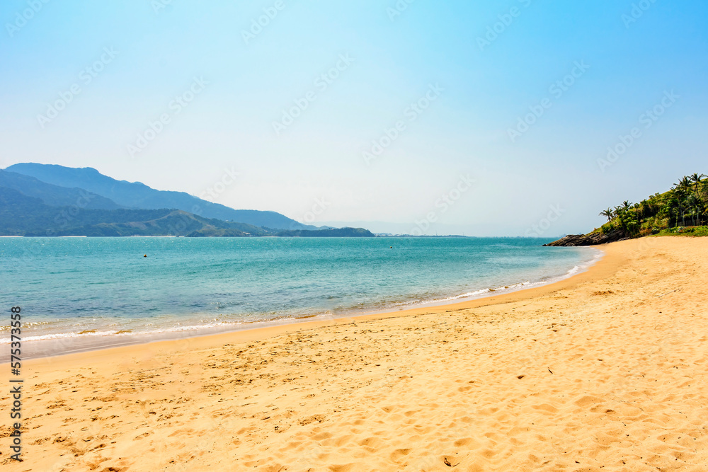 Beach on the island of Ilhabela on the north coast of the state of Sao Paulo with Sao Sebastiao hills in the background on a sunny day