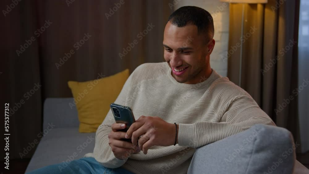 African american latino man 30s businessman ethnic freelancer consumer hold mobile phone gadget using smartphone apps shopping online at home chatting send sms messages browsing internet on cellphone African american latino man 30s businessman ethnic freelancer consumer hold mobile phone gadget using smartphone apps shopping online at home chatting send sms messages browsing internet on cellphone