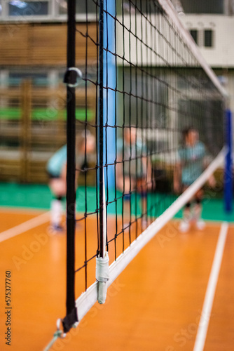 Sports image background for team volleyball games: volleyball game and net in an old school sport gym, selective focus. Concept of getting sport, healthy lifestyle and team success. Copy ad text space