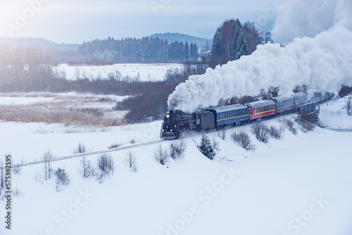 Retro steam train moves at winter day.