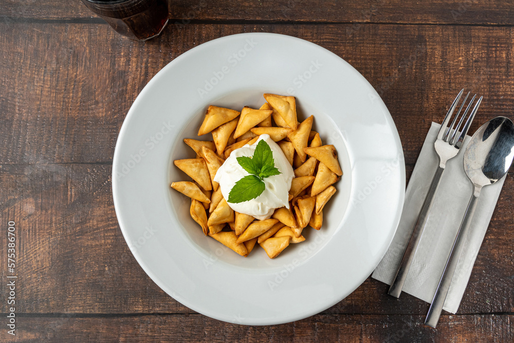 Deep fried crunchy Turkish ravioli or manti on a white porcelain plate Deep fried crunchy Turkish ravioli or manti on a white porcelain plate