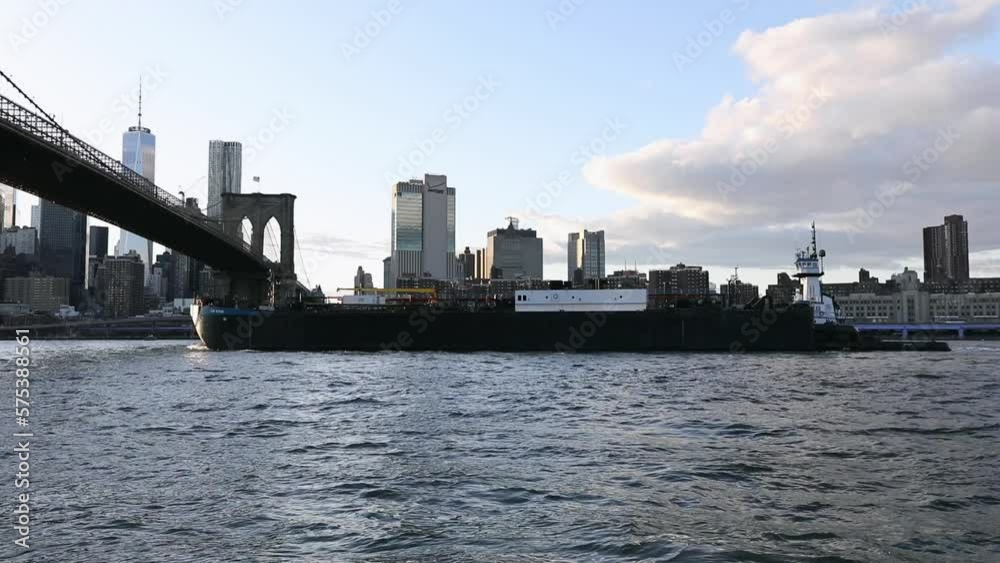 Dumbo in NYC and Barge on East River. NYC Cityscape and Brooklyn Bridge in Background Dumbo in NYC and Barge on East River. NYC Cityscape and Brooklyn Bridge in Background