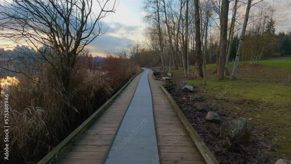 Trail by Peaceful Lake in the modern city, Deer Lake Park. Burnaby, Vancouver, BC, Canada. Colorful Winter Sunset Sky. Slow Motion Cinematic Pan.