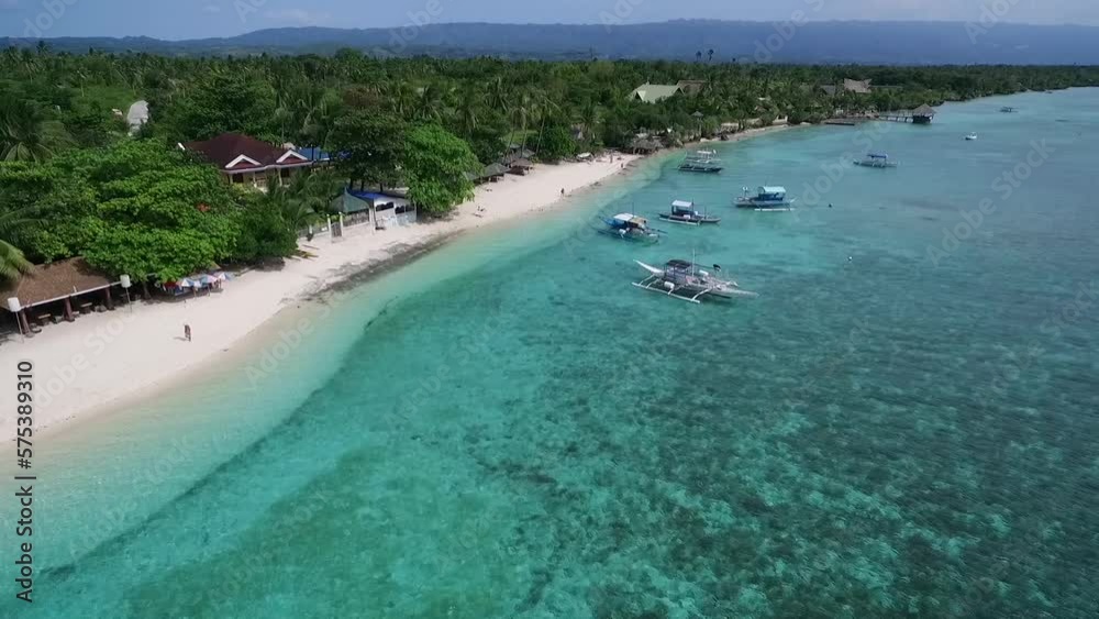 White Beach in Moalboal, Cebu, Philippines. Beautiful Landscape with Seashore and People in Background White Beach in Moalboal, Cebu, Philippines. Beautiful Landscape with Seashore and People in Background