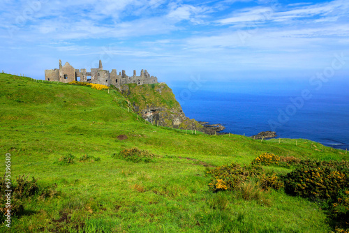 Ruins of the medieval Dunluce Castle along the green cliffs of the Causeway Coast  Northern Ireland