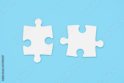 Two empty white matching puzzle pieces on blue background