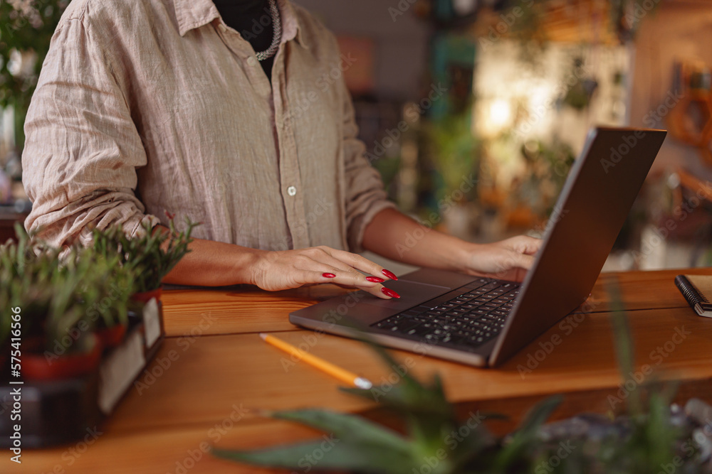CLose up of female florist working online from own floral studio and check customers order CLose up of female florist working online from own floral studio and check customers order