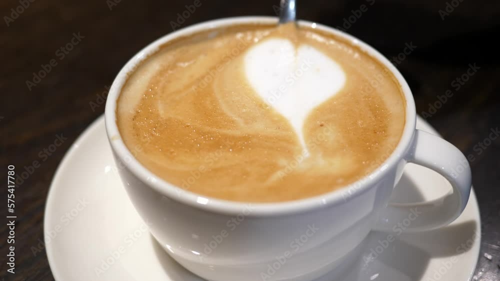 Cappuccino morning cup closeup with a drawing of heart milk foam art Cappuccino morning cup closeup with a drawing of heart milk foam art