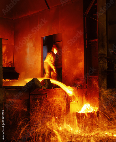 Tableau sur toile Obrero trabajando  hierro fundido en una fundidora industrial a altas temperaturas con equipo de protección