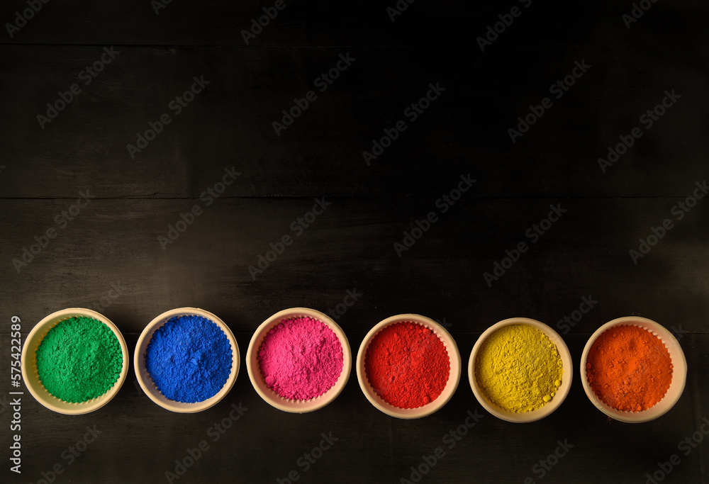 top view of colorful traditional holi powder in bowls isolated on dark background.Space for text . happy holi.Concept Indian color festival called Holi top view of colorful traditional holi powder in bowls isolated on dark background.Space for text . happy holi.Concept Indian color festival called Holi