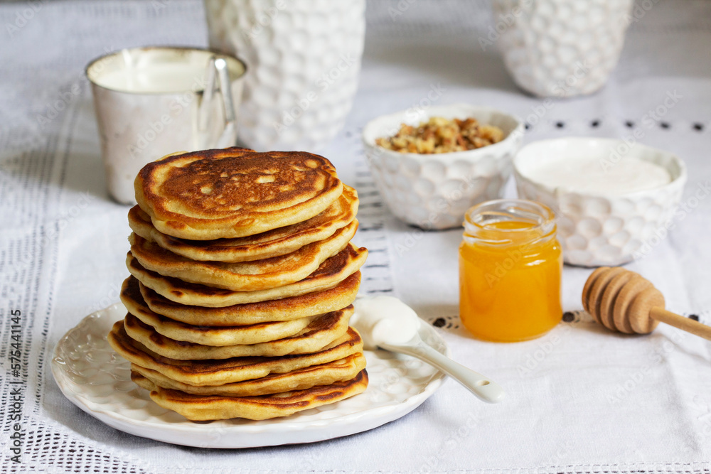 Apple pancakes served with honey, sour cream, nuts, tea and coffee.