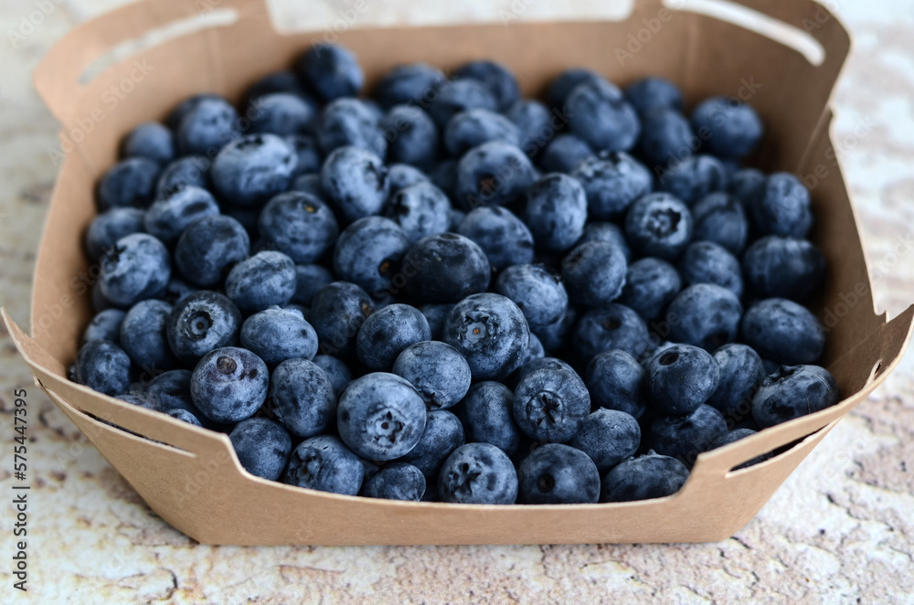 Fresh tasty blueberries in a cardboard container on an abstract background. Healthy food concept. Source of vitamins
Fresh tasty blueberries in a cardboard container on an abstract background. Healthy food concept. Source of vitamins