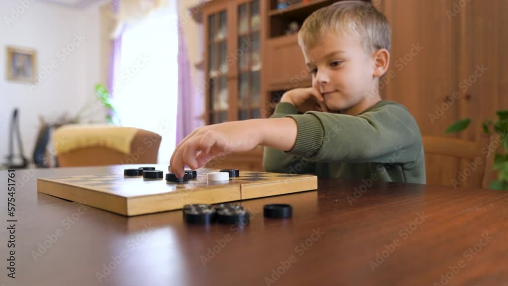 Little boy child play checkers with grandmother. The boy won Little boy child play checkers with grandmother. The boy won