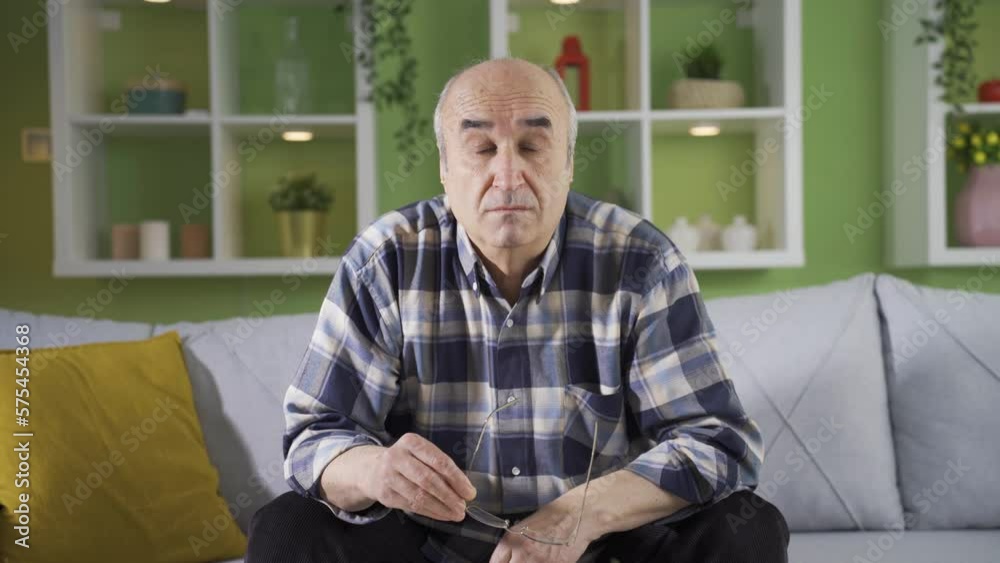 Elderly man with visual impairment wearing glasses and being happy. Trying to look at the camera