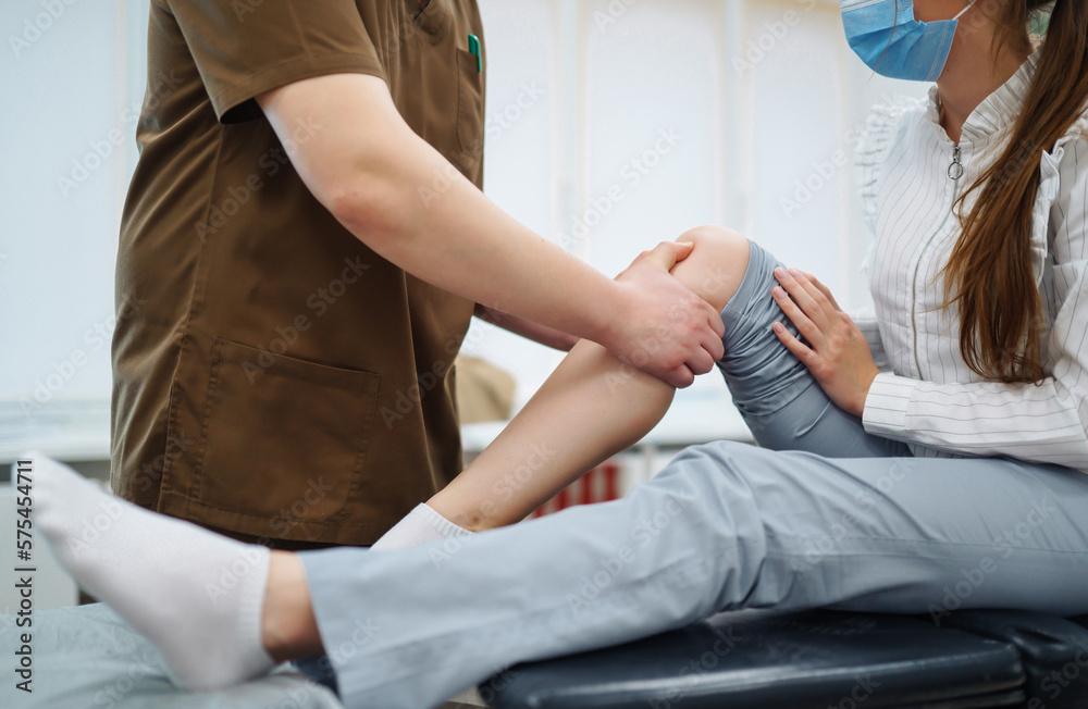 Foto de Doctor examining female patient with injured leg. Osteopathy