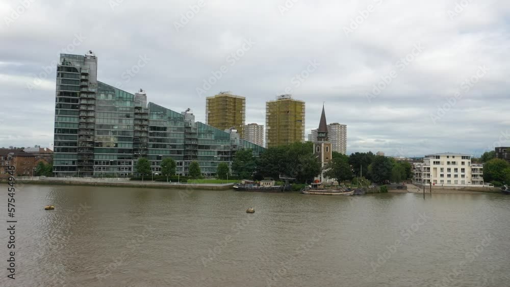 Thames river. Heading to Montevetro building and St Mary's Church in Battersea borough. Overcast sky Thames river. Heading to Montevetro building and St Mary's Church in Battersea borough. Overcast sky
