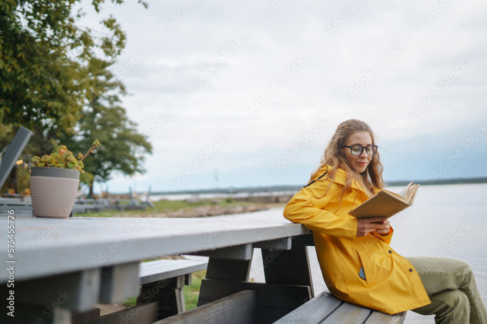 Young  woman reading a book in the park. Relaxation, enjoying, solitude with nature.