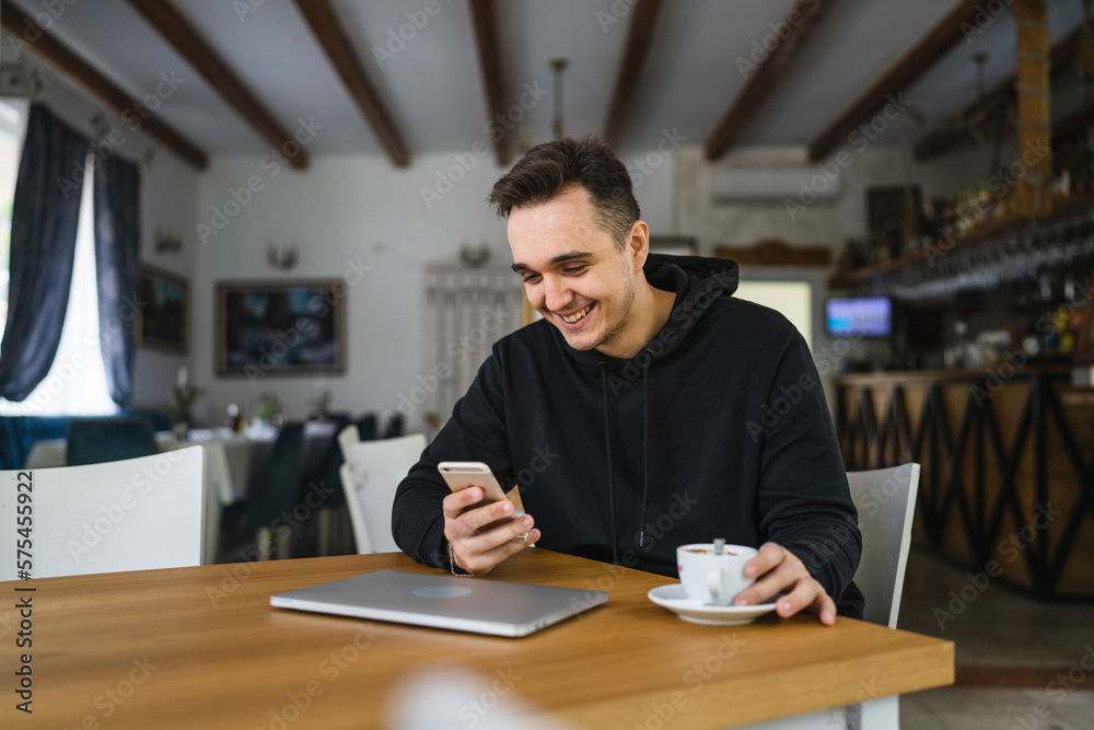 Fototapeta premium one man use mobile phone while sit at the table at restaurant