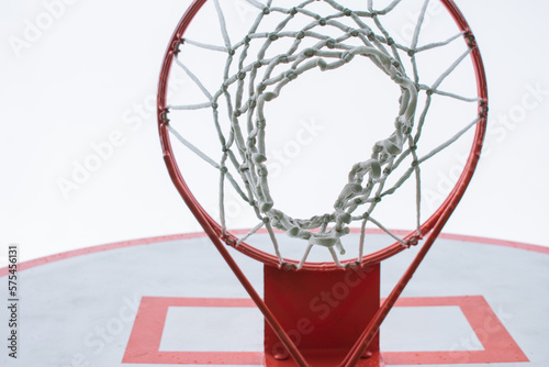 Looking up through a basketball hoop and net into an overcast sky © thelittlecactus
