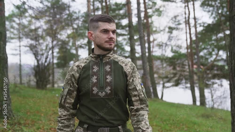 Smiling soldier in uniform greeting while walking outdoors. Slow-motion Smiling soldier in uniform greeting while walking outdoors. Slow-motion