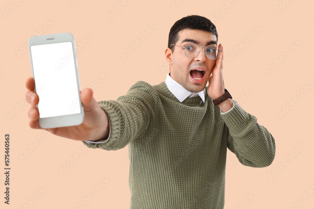 Surprised young man in eyeglasses on beige background Surprised young man in eyeglasses on beige background